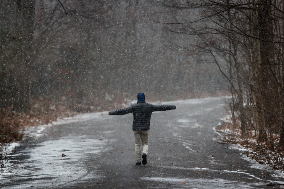 <strong>A walker makes his way through Overton Park as snow falls on Dec. 26, 2022.</strong> (Mark Weber/The Daily Memphian file)