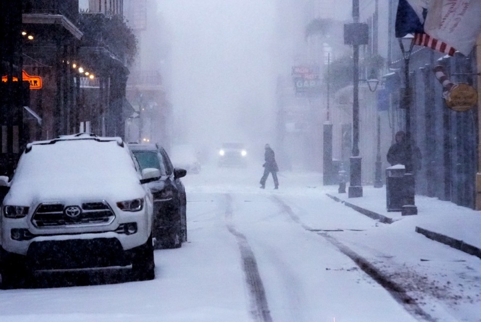 <strong>Pedestrians walk through the French Quarter during a very rare snowstorm in New Orleans, Tuesday, Jan. 21, 2025.</strong> (AP Photo/Gerald Herbert)