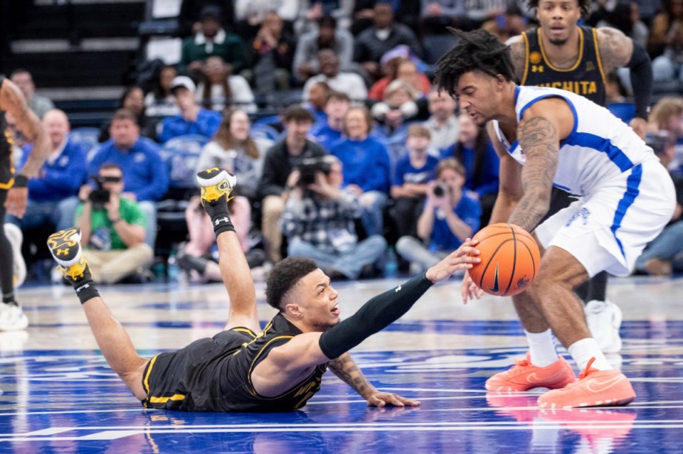 <strong>Wichita State guard Xavier Bell, left, tries to steal the ballfrom from Memphis guard PJ Haggerty by diving for it.</strong> (Nikki Boertman/AP)