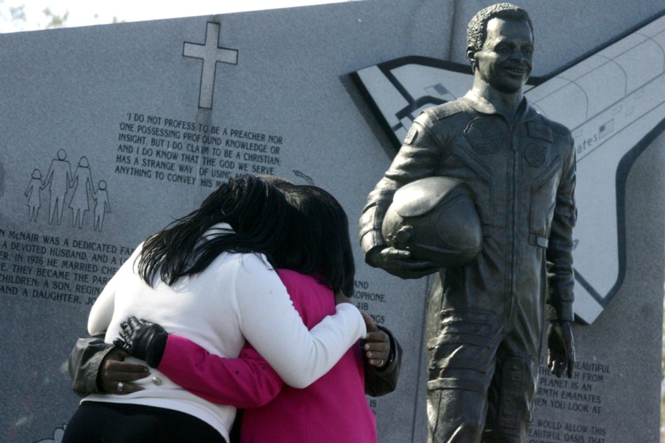 <strong>Joy McNair, left, daughter, Reginald McNair, son, and Cheryl McNair, wife, embrace under a statue of Lake City, S.C. astronaut Ron McNair at Ron McNair Memorial Park in Lake City, Saturday, Jan. 28, 2006. McNair died Jan. 28, 1986, along with six other astronauts when the space shuttle Challenger exploded.</strong> (Heidi Heilbrunn/AP Photo Morning News file)