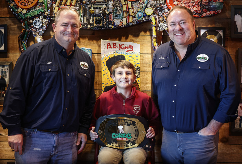 <strong>St. George&rsquo;s student Bryan Storz, age 10, (middle) received a #1 fan Corky's wrestling belt from the restaurant&rsquo;s director, accounts &amp; business development Tom Cassidy (left) and owner Jimmy Stovall (right).</strong> (Mark Weber/The Daily Memphian)