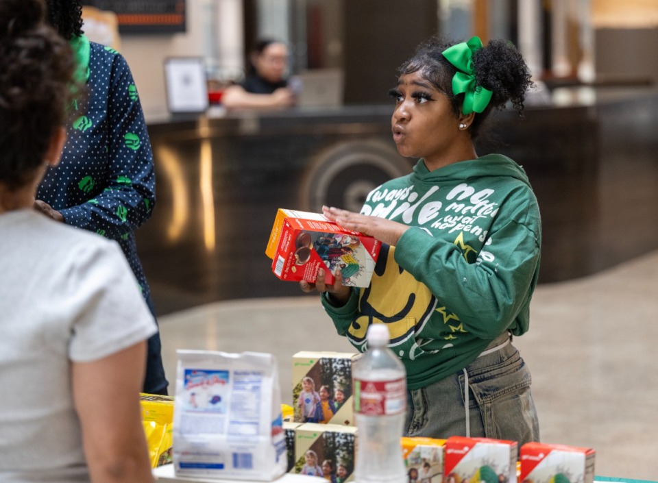 <strong>Girl Scout Preauna Richardson gathers up an order of cookies for a custormer at Crosstown Concourse on Feb. 8. Girl Scout Troop 13366 meets in the Concourse for their regular meetings.</strong> (Greg Campbell/Special to The Daily Memphian)