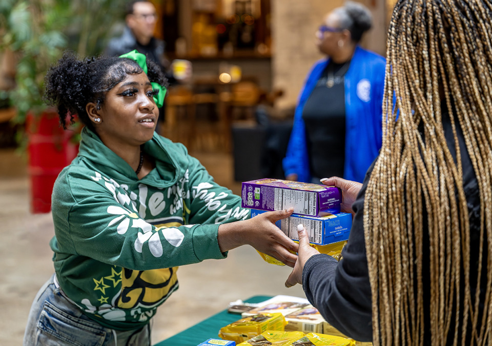 <strong>Girl Scout Troop 13366 member, Preauna Richardson, hands over boxes of Girl Scout cookies to a customer at the Crosstown Concourse, Saturday, Feb. 8, 2025.</strong> (Greg Campbell/Special to The Daily Memphian)