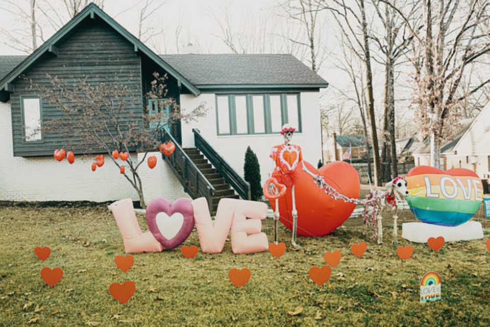 <strong>Alexis Luttrell has redecorated her yard for Valentine&rsquo;s Day. The skeletal human is wearing a red-and-white tie-dye heart shirt, a red flower crown, and a red tutu, holds an inflatable heart and a red-and-silver leash, and the dog sports a matching red flower crown and a &ldquo;Free Kisses&rdquo; bandana. They are surrounded by two inflatable hearts, an inflatable &ldquo;Love&rdquo; sign, multiple heart decorations, and a &ldquo;Love is Love&rdquo; sign.</strong> (Courtesy Foundation for Individual Rights and Expression)