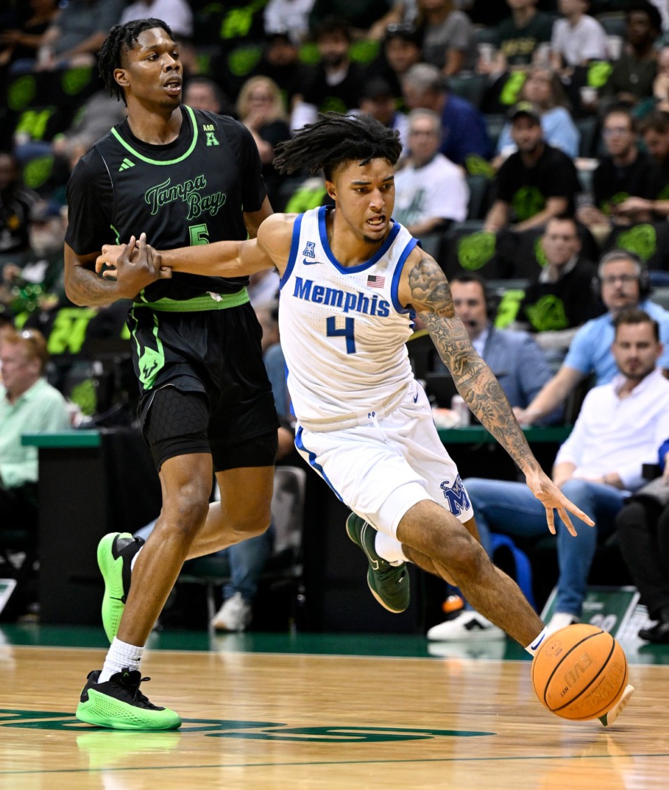 <strong>Memphis guard PJ Haggerty (4) drives to the basket against South Florida guard Brandon Stroud (5) on Thursday, Feb. 13, 2025, in Tampa, Florida.</strong> (Jason Behnken/AP)