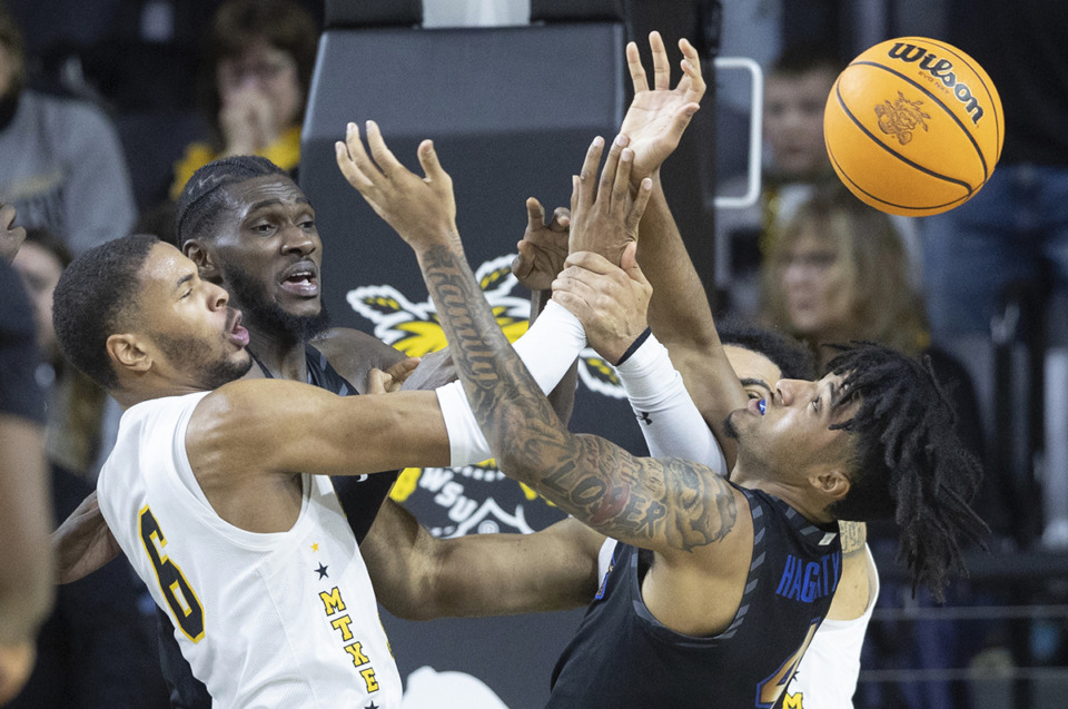 <strong>Memphis guard PJ Haggerty, right, fights for a rebound against Wichita State's Corey Washington, left, and teammate Moussa Cisse during the first half of an NCAA college basketball game, Sunday, Feb. 16, 2025, in Wichita, Kan.</strong> (Travis Heying/AP Photo)