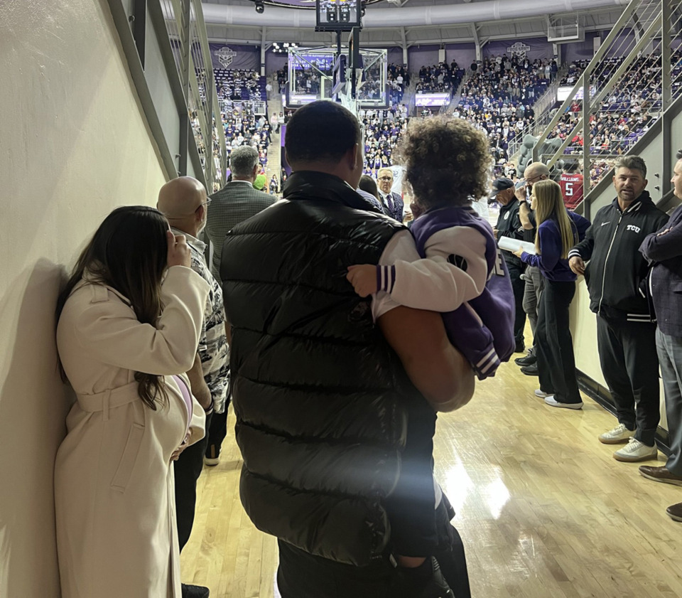 <strong>Desmond Bane holds his son Armani while he waits in the tunnel for the jersey-retirement ceremony. His wife Tatum is to his left, in front of her is Tony Bane.</strong> (Drew Hill/The Daily Memphian)