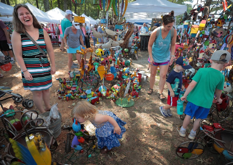 <strong>Families peruse the wares at the Kelly's Crossing booth during the 48th Germantown Festival on Sept. 7, 2019, at Morgan Woods Park.&nbsp;The annual event features rides, food trucks, over 350 craft booths and the fan favorite Running of the Weenies dog races.</strong>(Jim Weber/Daily Memphian)