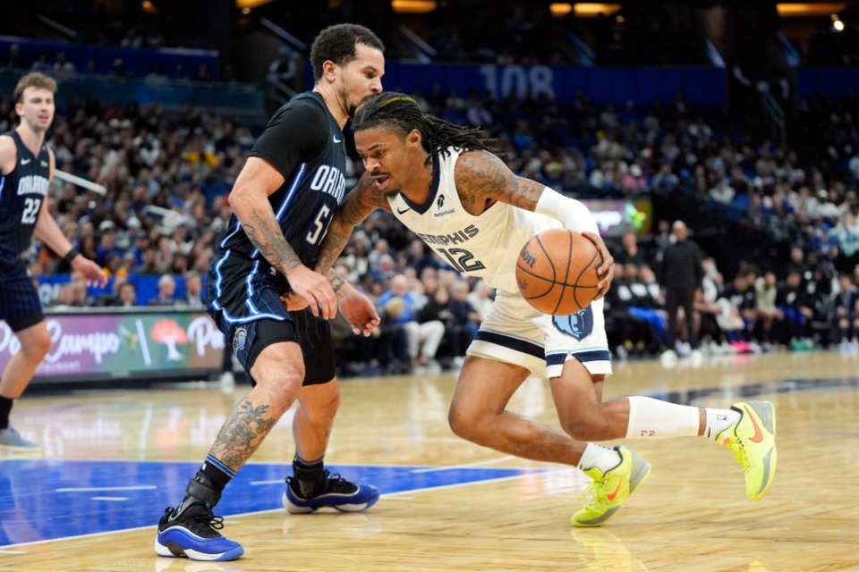 <strong>Memphis guard Ja Morant (12), who led the Grizzlies with 23 points, drives around Orlando Magic guard Cole Anthony, left, on Friday, Feb. 21, 2025, in Orlando, Fla.</strong> (John Raoux/AP)