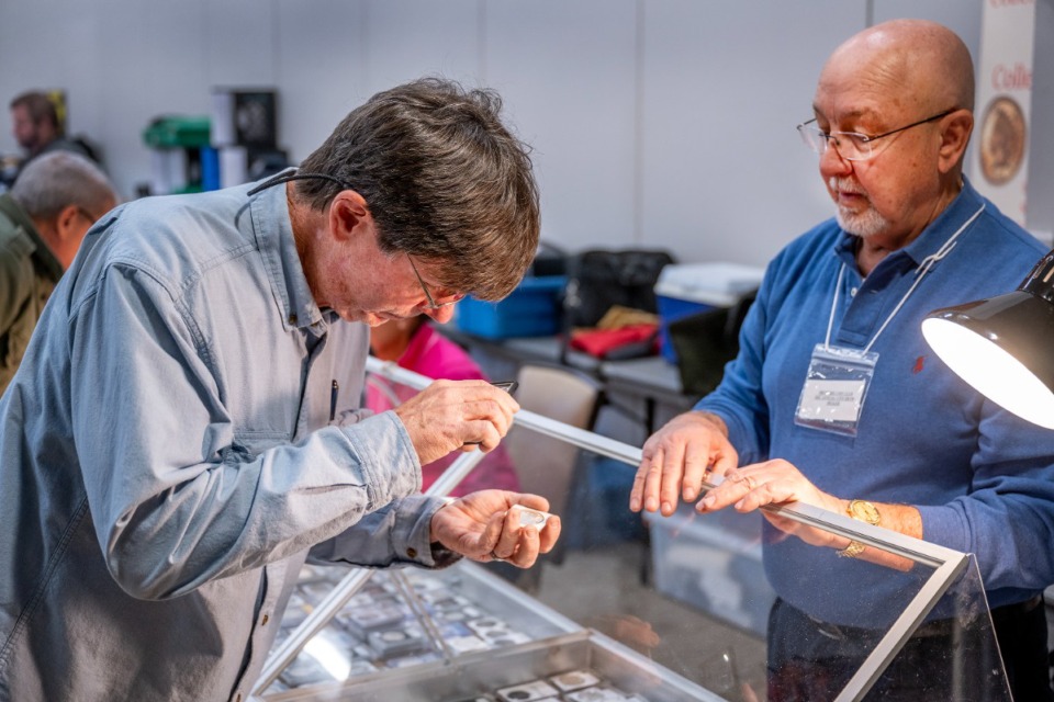 <strong>Alan Ladd of Coldwater, Miss., examines a coin from Nick Lagattuta of Coaches Coins in New Orleans at the 2025 annual Memphis Coin Club Show at the Landers Center in Southaven.</strong> (Greg Campbell/Special to The Daily Memphian)