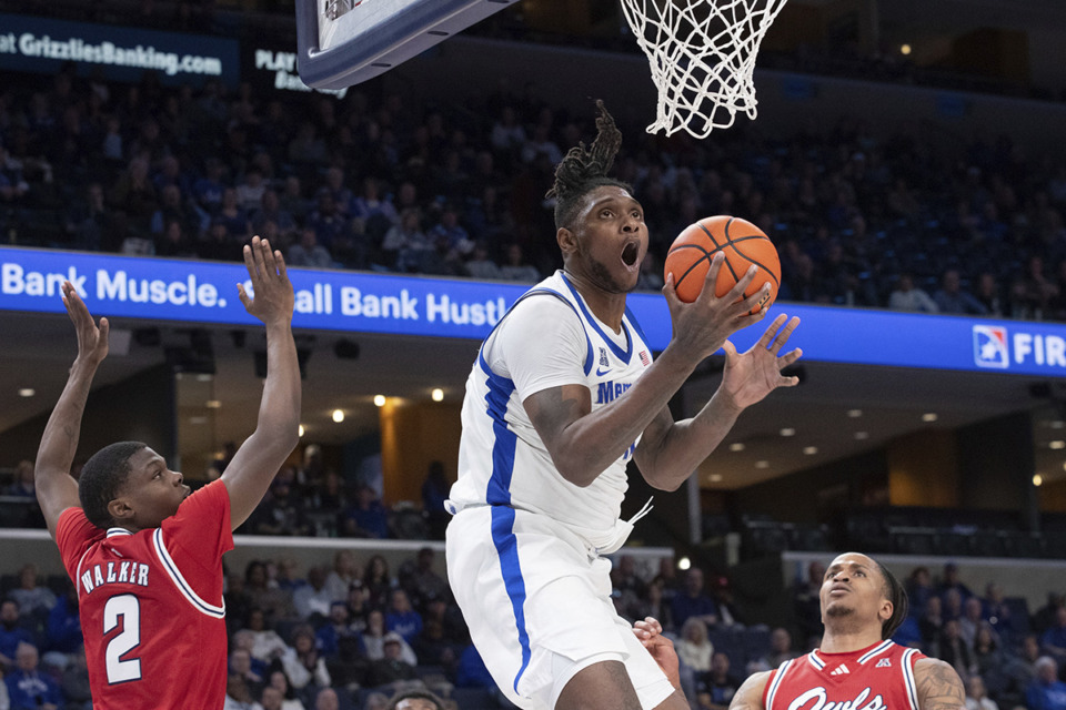 <strong>Memphis forward Dain Dainja, center, looks to shoot while defended by Florida Atlantic guard Leland Walker (2) and forward Kaleb Glenn, right, during the first half of an NCAA college basketball game Sunday, Feb. 23, 2025, in Memphis.</strong> (Nikki Boertman/AP Photo)