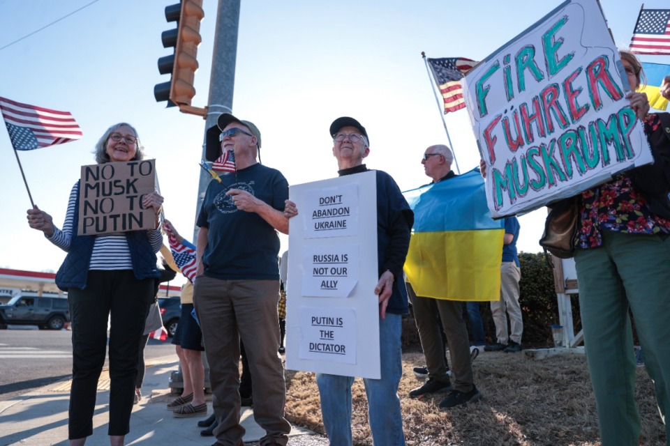 <strong>Hunter Oppenheimer (from left), Herb Kinnnimonth and Mary Nease protest President Donald Trump's response to the war in Ukraine at the corner of Poplar Avenue and Highland Street Feb. 26, 2025.</strong> (Patrick Lantrip/The Daily Memphian)