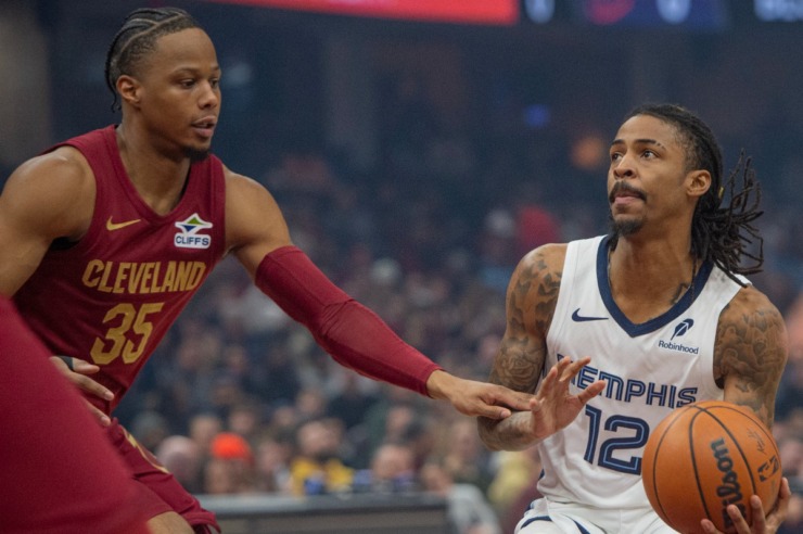 Memphis Grizzlies' Ja Morant (12) prepares to shoot as Cleveland Cavaliers' Isaac Okoro (35) defends during the first half of an NBA basketball game in Cleveland, Sunday, Feb. 23, 2025. (AP Photo/Phil Long)