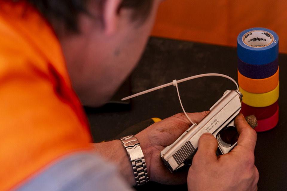 <strong>A handgun is inspected during the Guns to Gardens event, where unwanted guns were dismantled to be transformed into garden tools.</strong> (Brad Vest/Special to The Daily Memphian)