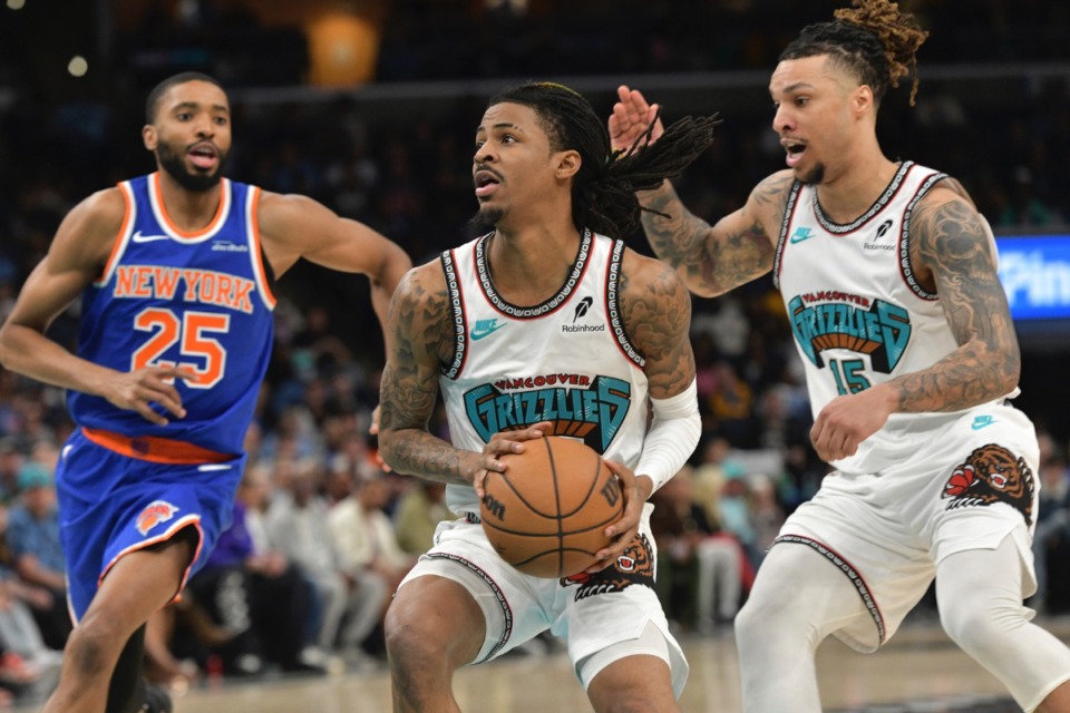 <strong>Memphis Grizzlies guard Ja Morant, center, handles the ball ahead of New York Knicks forward Mikal Bridges (25) and forward Brandon Clarke (15) in the first half of an NBA basketball game Friday, Feb. 28, 2025, in Memphis, Tenn.</strong> (AP Photo/Brandon Dill)