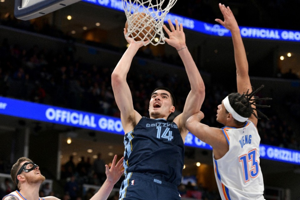 <strong>Memphis Grizzlies center Zach Edey (14) shoots between Oklahoma City Thunder forward Ousmane Dieng (13) and center Isaiah Hartenstein (55) on Wednesday, March 5, 2025.</strong> (Brandon Dill/AP)