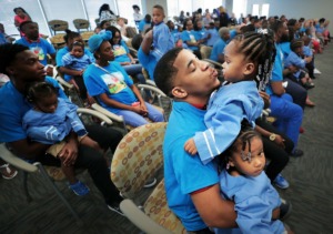 <strong>Kevin Broady tries to keep his twin one-year-old girls Serenity Broady and Kennedi Broady (right) entertained during a graduation ceremony for parents and kids in Le Bonheur's Nurse-Family Partnership at the hospital's community outreach center on Aug. 2, 2019. The program connects nurses with first-time pregnant mothers to guide them through early child development.</strong> (Jim Weber/Daily Memphian)