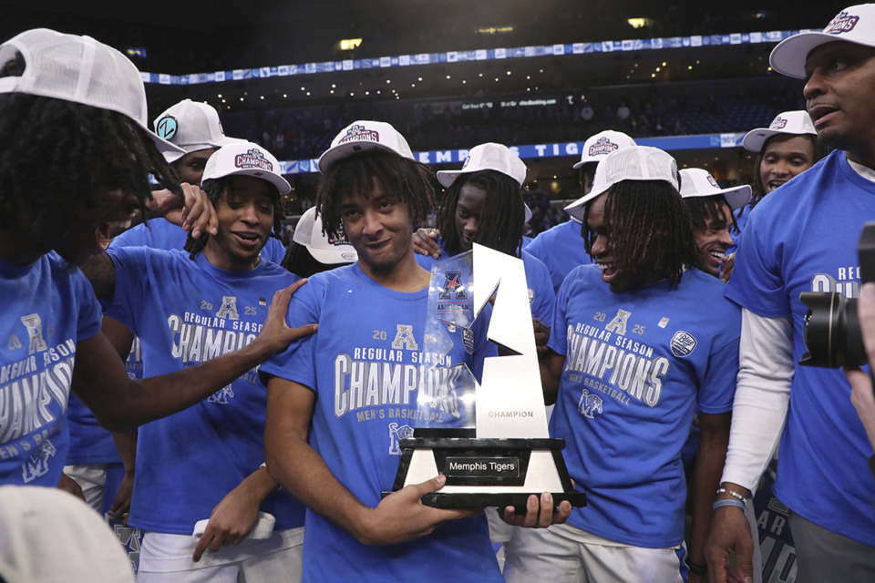 <strong>Tigers guard PJ Haggerty, center, holds the trophy as the team claims the American Athletic Conference regular-season championship following an NCAA college basketball game against South Florida on March 7.</strong> (Nikki Boertman/AP file)