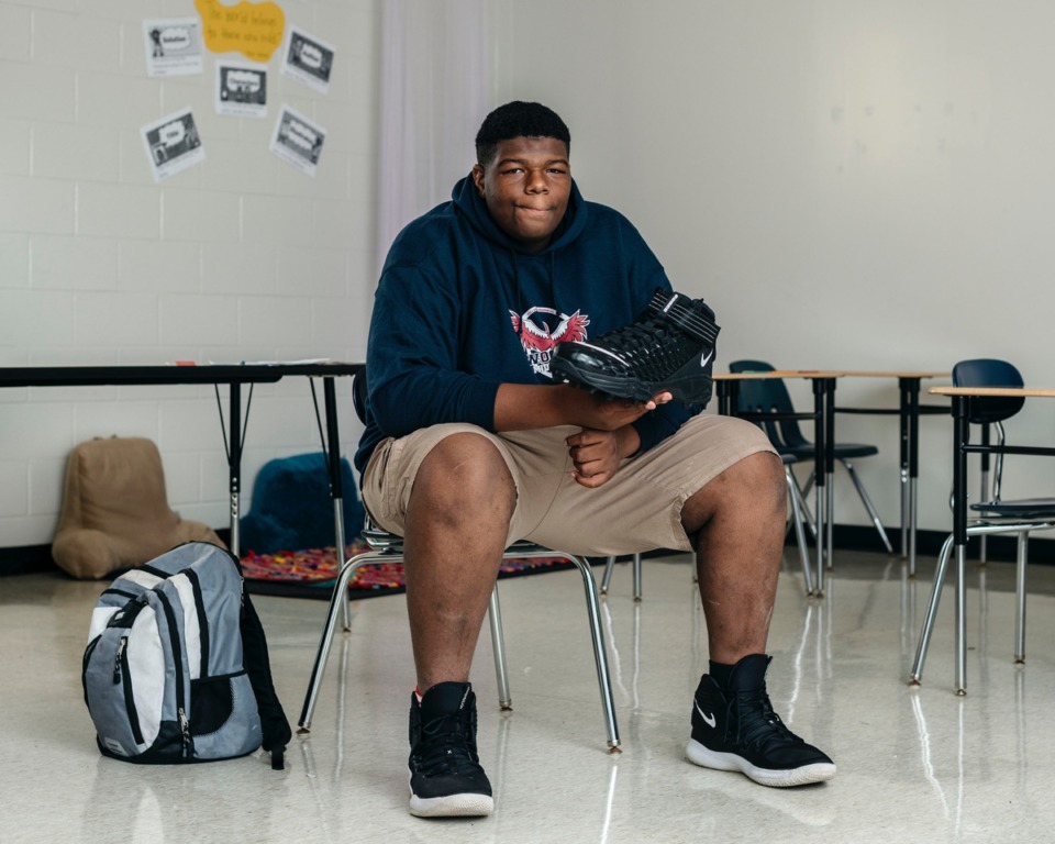 <strong>Timothy Lewis, a seventh-grade nose guard on the Wooddale Middle School football team, tries on his new Nike size-22 cleats for the first time. Lewis has struggled to find cleats his size and had to search nationwide before finding a pair that fit.</strong> (Houston Cofield/Special to The Daily Memphian)