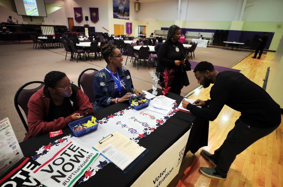<strong>Siju Crawford (right) signs in at a voter registration table at an Up the Vote Block Party on Oct. 31, 2018, at First Baptist Church on Broad Avenue in Memphis. On Thursday, Sept. 12, 2019, a federal judge blocked the state&rsquo;s new voter registration law, a reaction to a large number of applications filed in Shelby County in 2018.&nbsp;</strong>(Jim Weber/Daily Memphian)