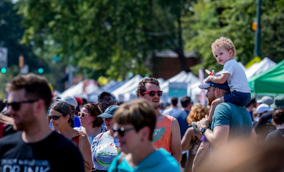 <strong>Ward Barnhart (right), 3, chews on a popsicle while he surveys the sea of visitors at Cooper-Young Festival on Saturday, Sept. 14, 2019. The festival drew thousands of visitors from around the south to enjoy live music, local artwork and food.</strong> (Houston Cofield/Special To The Daily Memphian)