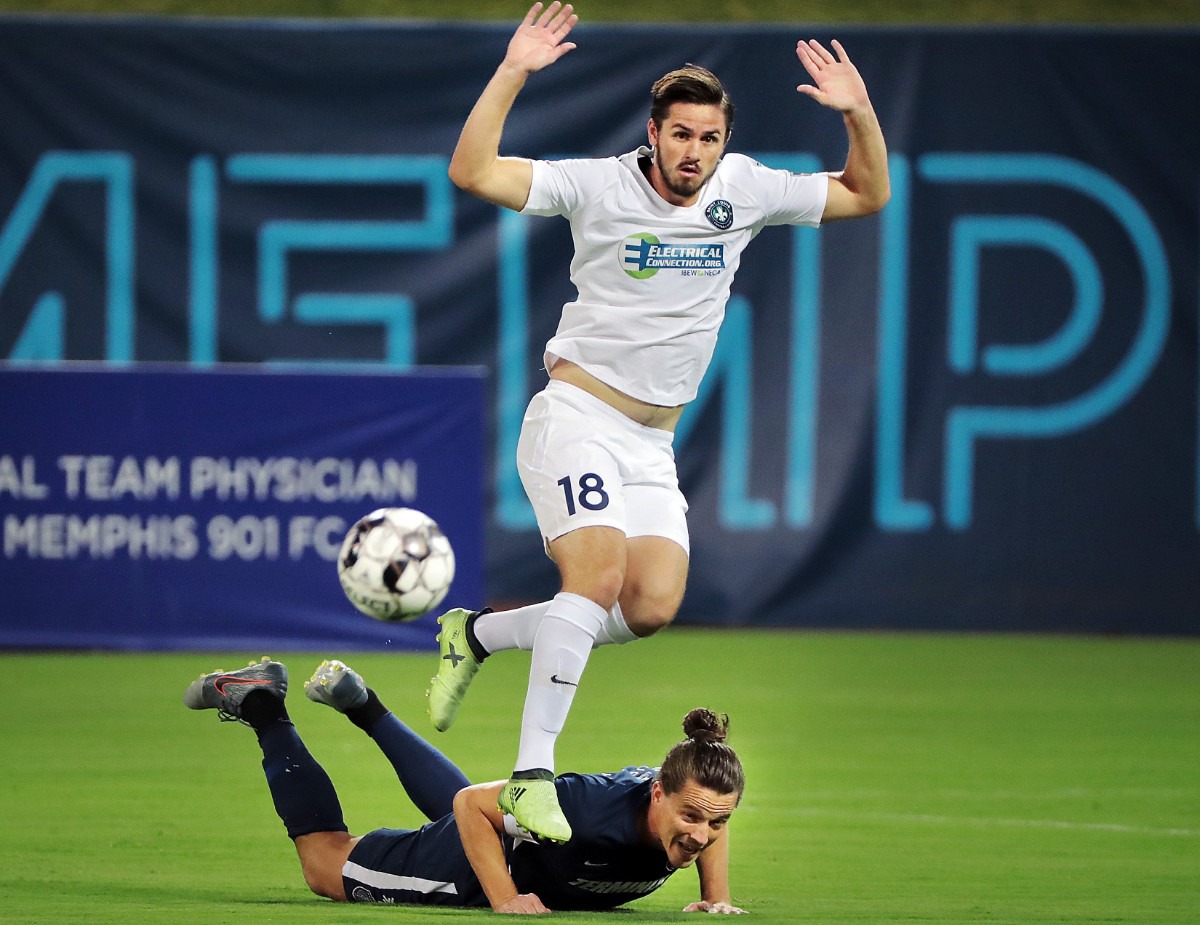 <strong>The St. Louis FC squad's Caleb Calvert (18) hurdles Memphis defender Marc Burch on a steal in the first half during 901FC's 1-0 win over St. Louis at AutoZone Park on Sept. 21, 2019.</strong> (Jim Weber/Daily Memphian)