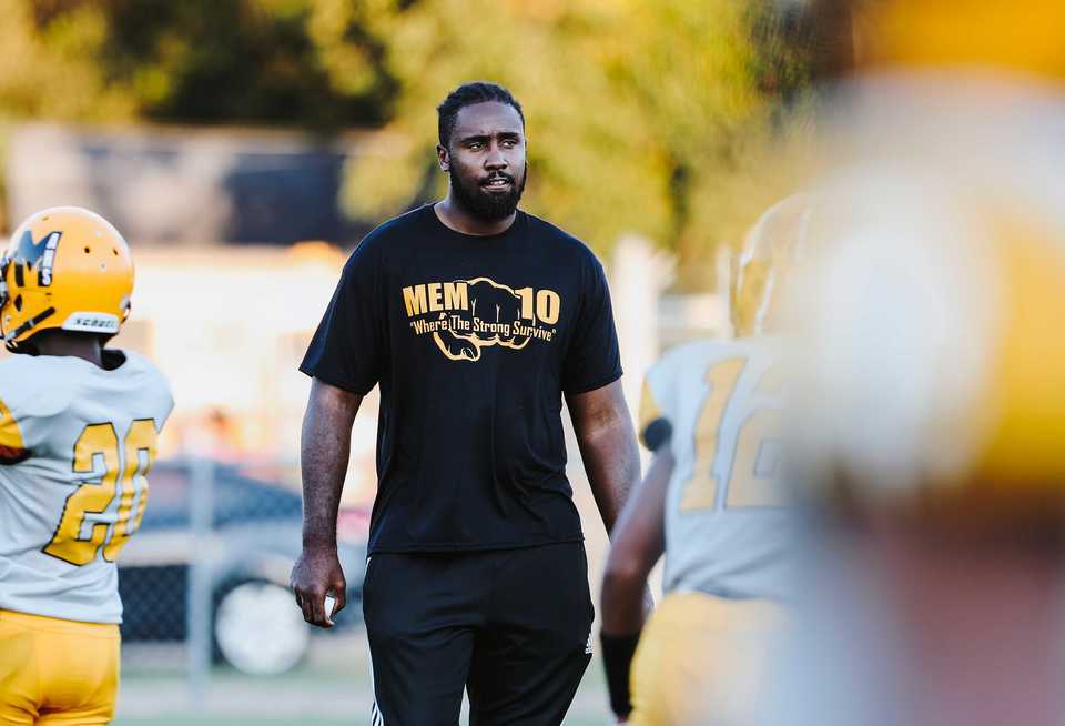 <strong><span>Memphis Academy of Health Sciences</span> offensive line coach Christian Johnson walks through lines of players during a pre-game stretch before their matchup against Craigmont on Sept. 20, 2018.</strong> (Houston Cofield/Daily Memphian)