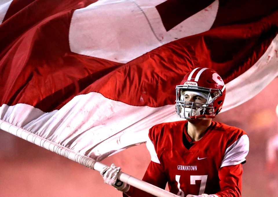 <strong>Germantown's Tyler Miller waves the school's flag as the team enters their home stadium prior to their game against Whitehaven on Friday, Oct. 26.</strong>&nbsp;(Houston Cofield/Daily Memphian)