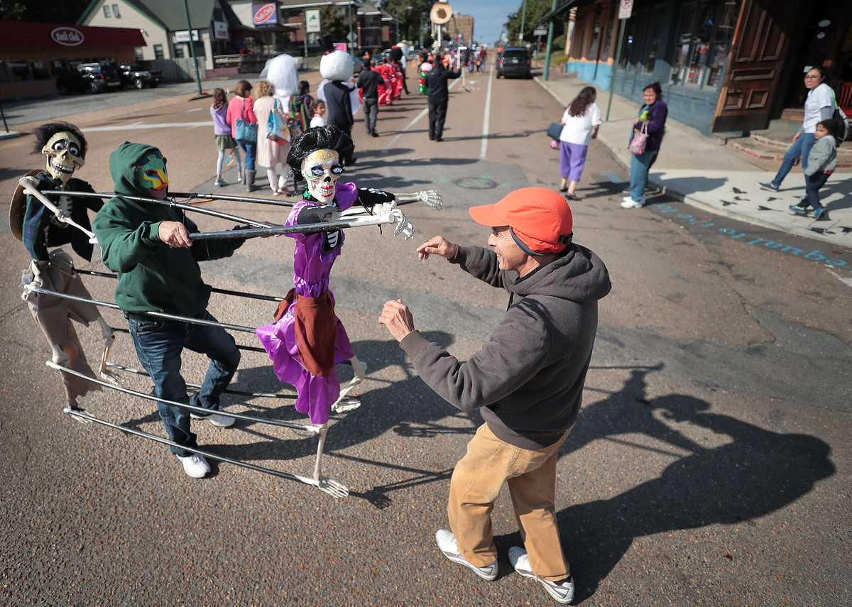 <strong>Angel Gonzalez (right) dances with Addofo Montiel and his skeleton puppets during the a Dia de los Muertos (Day of the Dead) parade from Overton Square to Overton Park on Oct. 27, 2018. The parade and fiesta are put on by the Brooks Museum of Art and Cazateatro Bilingual Theatre Group drawing from the Latin American tradition of honoring ancestors and celebrating the cycle of life and death.</strong> (Jim Weber/Daily Memphian)