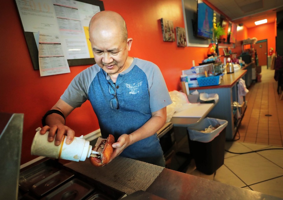 <strong>Chris Truong adds mayo to a banh mi sandwich at the Ong Cau Cafe in Cordova. Ong Cau, which means 'great uncle', is the most recent iteration of a family tradition for Truong who works with his sisters to create authentic Vietnamese fare.</strong> (Jim Weber/Daily Memphian)