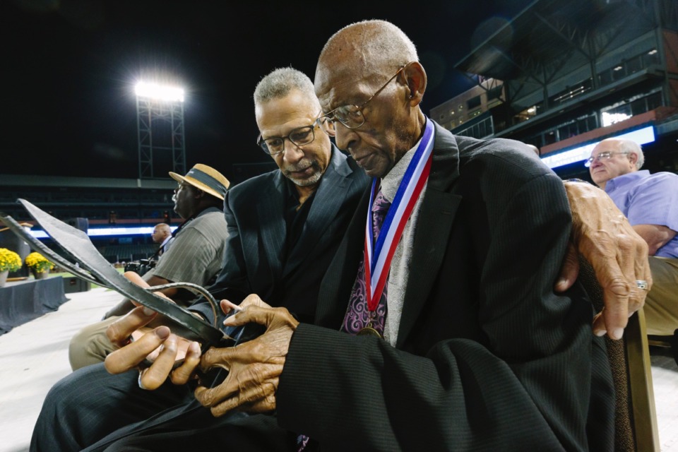 <strong>Dr. Jerry C. Johnson (left) and his father, 101-year-old inductee Jerry Johnson, admire the award from the inaugural Memphis Sports Experience and Hall of Fame ceremony at AutoZone Park Oct. 10.</strong> (Ziggy Mack/Daily Memphian)