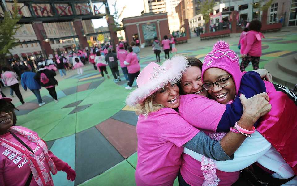 <strong>Fellow breast cancer survivors Barbara Gaston (left), Dana Sloan and Kari Daniel embrace before the start of the Susan G. Komen Race for the Cure on Oct. 27, 2018. Downtown was flooded with pink tutus, pink wigs and pink feathered boas Saturday morning as over 6,000 runners turned out for the annual race to raise money to fund research, education, screening and treatment of breast cancer.</strong> (Jim Weber/Daily Memphian)