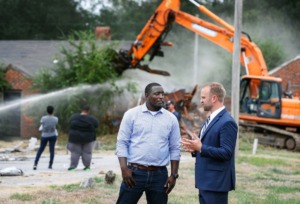 <strong>General Contractor Octavius Nickson (left) and Noah Gray, executive director of the Binghampton Development Corp., chat as a bulldozer razes vacant homes on Tillman Cove. during 'Demolition Day' ceremony Sept. 9.</strong> (Mark Weber/Daily Memphian file)