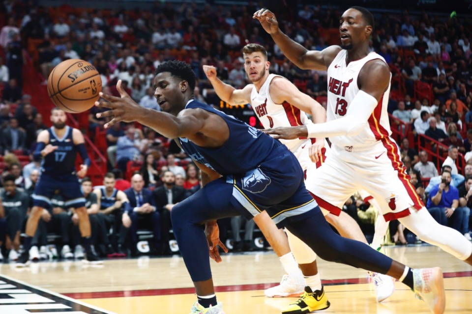 <strong>Grizzlies forward Jaren Jackson Jr. dives for the ball in front of Miami Heat's Bam Adebayo (13) and Meyers Leonard Oct. 23 in Miami.</strong> (Brynn Anderson/AP)