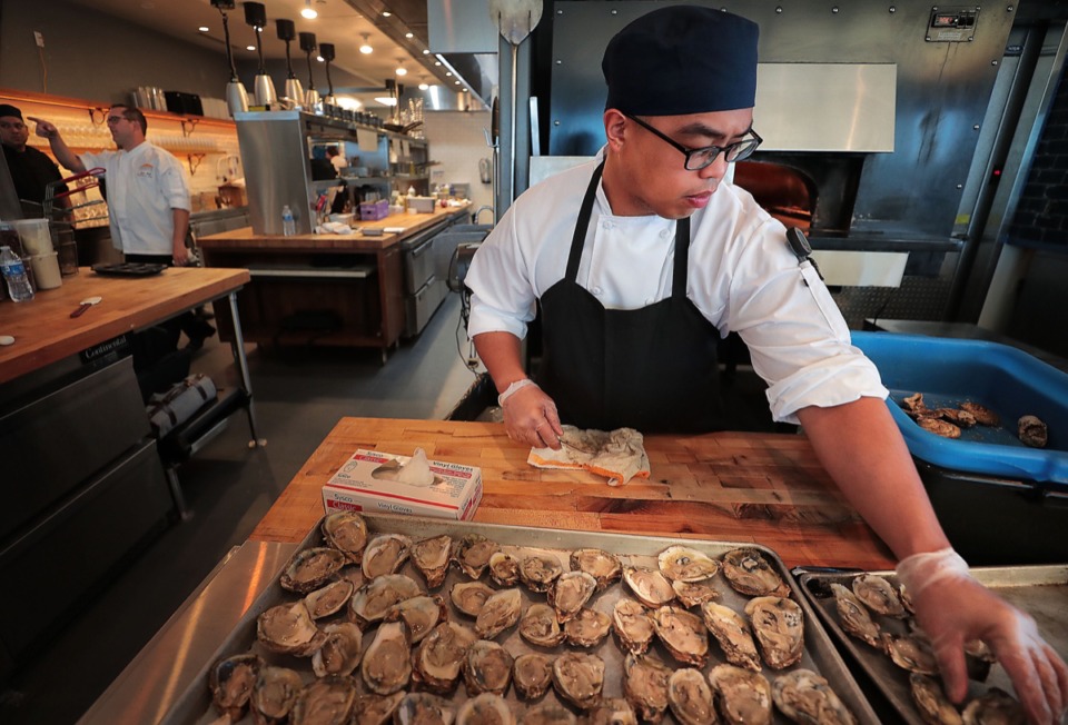 <strong>Rocky Iganda shucks oysters as staff trains for the upcoming opening of Coastal Fish Company, the new restaurant that will open in the nearly 5,000-square-foot space in the FedEx Event Center at Shelby Farms.</strong> (Jim Weber/Daily Memphian)