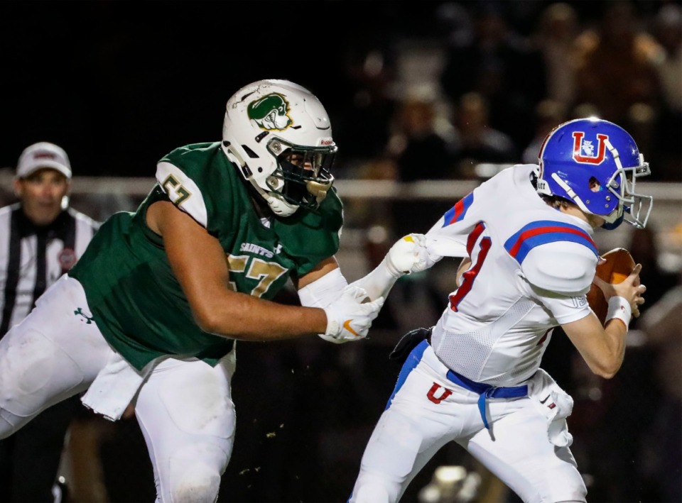 <strong>Briarcrest defender Omari Thomas (left) hangs on to MUS quarterback Edwin Shy (with ball) to record a sack Nov. 1.</strong> (Mark Weber/Daily Memphian)