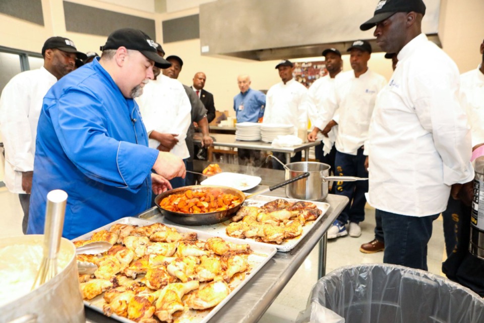 <strong>Chef William Mullins (left), leads a class at the Shelby County Corrections Department on Mullins Station Road. Mullins, a professor at the Kemmons Wilson Culinary Institute, teaches inmates enrolled in the U of M's culinary fundamentals course.</strong> (Micki Martin/Martin Family Foundation)