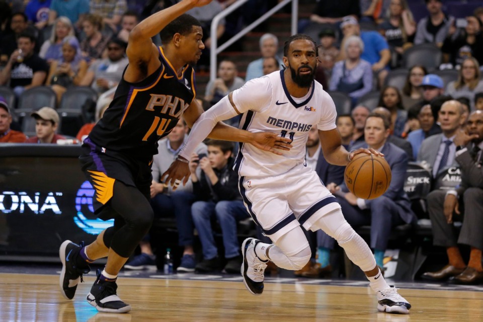 <strong>Mike Conley (right), in his Grizzlies days, drives past Phoenix Suns guard De'Anthony Melton on March 30, 2019, in Phoenix.</strong> (Rick Scuter/AP)