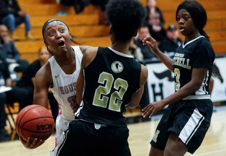 <strong>Houston guard Destinee Wells (left) is fouled by Mitchell defender Melisha Green (middle) while driving the lane during action in their basketball game Monday, Nov. 18.</strong> (Mark Weber/Daily Memphian)