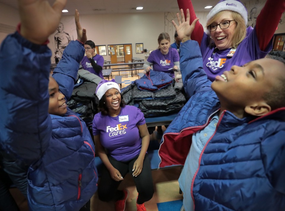 <strong>FedEx employees Sherita Coleman (center) and Patricia Cranston help classmates D'Nero Shields (left) and Kentarius Carpenter pick out matching coats as kids try on their new coats from Operation Warm, which distributes winter coats to children at schools around the country, during a giveaway in conjunction with FedEx at Bruce Elementary School on Nov. 22, 2019.</strong> (Jim Weber/Daily Memphian)