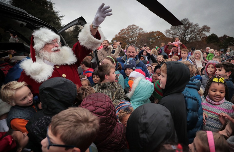 <strong>A mob of kids greet Santa (Jack Schafer) as he arrives by helicopter at the Pink Palace Museum on Nov. 23, 2019, to officially open the Enchanted Forest Festival of Trees.</strong> (Jim Weber/Daily Memphian)