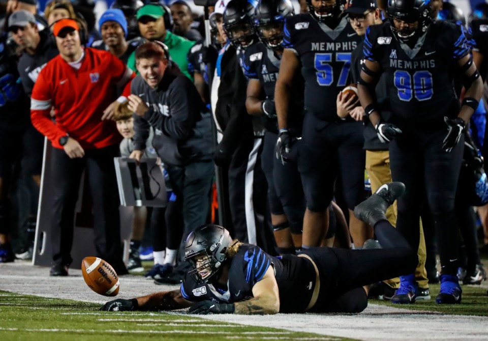 <strong>Memphis defender Jonathan Wilson (bottom) tries to stop a fumble from going out of bounds in the Nov. 29 game against Cincinnati.</strong> (Mark Weber/Daily Memphian)