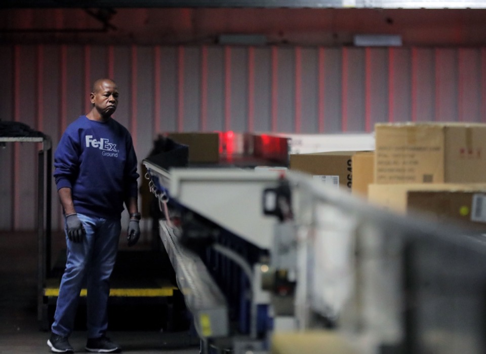 <strong>A FedEx Ground employee monitors the seemingly never-ending conveyor belt of packages ripping through the FedEx Ground hub in Olive Branch, Mississippi, on Dec. 2.</strong> (Patrick Lantrip/Daily Memphian)