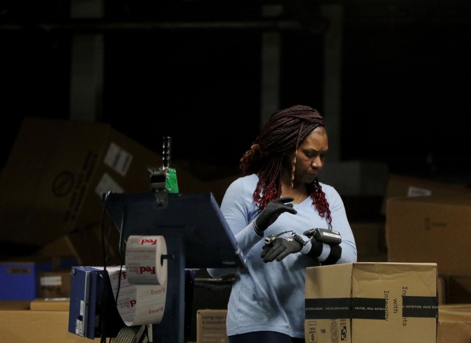 <strong>A FedEx Ground employee tags and scans a mountain of packages at the FedEx Ground hub in Olive Branch, Mississippi, Dec. 2.</strong> (Patrick Lantrip/Daily Memphian)