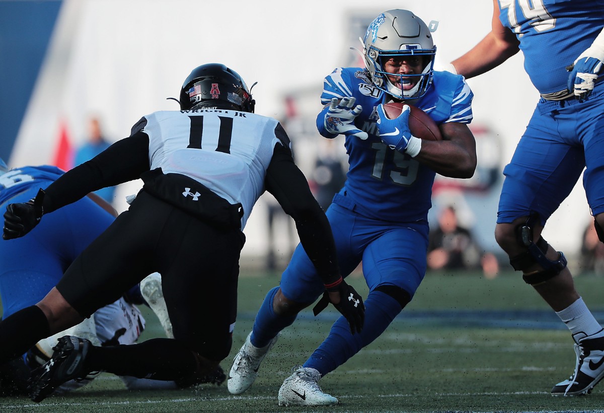 <strong>University of Memphis running back Kenneth Gainwell looks for an opening under pressure by Cincinnati's Leonard Taylor (11) during a run in the first half of the Tiger's AAC Championship game on Dec. 7, 2019, against the Bearcats at the Liberty Bowl Memorial Stadium.</strong> (Jim Weber/Daily Memphian)