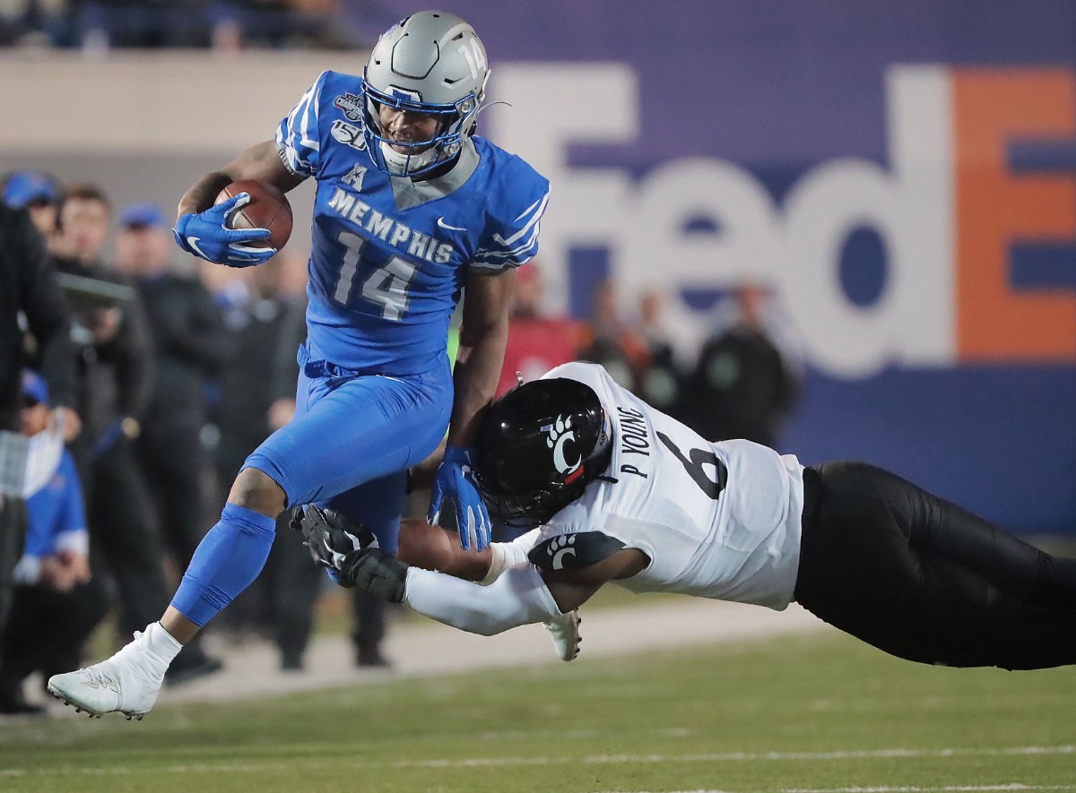 <strong>University of Memphis receiver Antonio Gibson (14) is taken down by Cincinnati's Perry Young during a run in the second half of the Tiger's AAC Championship game on Dec. 7, 2019, against the Bearcats at the Liberty Bowl Memorial Stadium.</strong> (Jim Weber/Daily Memphian)