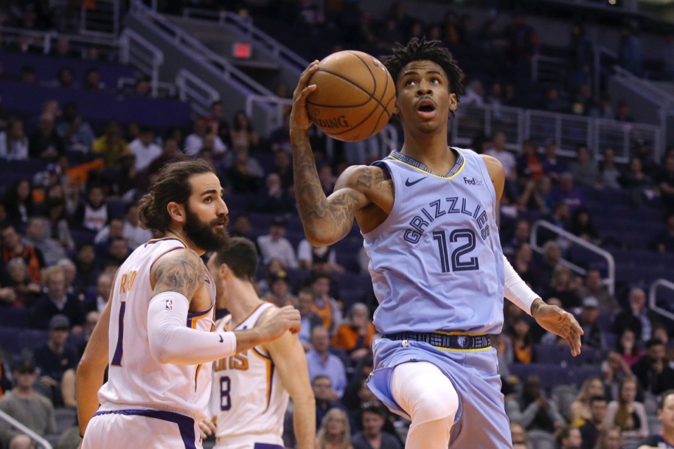 <strong>Grizzlies guard Ja Morant (12) drives past Phoenix Suns guard Ricky Rubio, left, Dec. 11 in Phoenix.</strong>&nbsp;<strong>He slammed an emphatic dunk in the fourth quarter to cap the Memphis win.</strong> (Ross D. Franklin/AP)