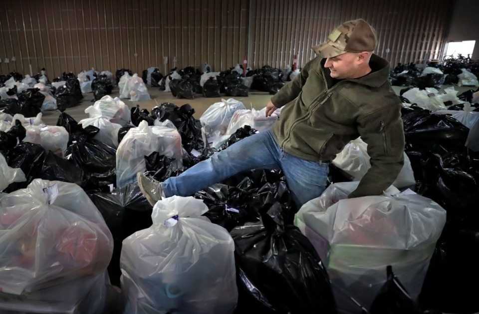 <strong>Marine Staff Sgt. Harris Andrew wades through bags of toys while volunteering to help out with the Toys for Tots drive on Brooks Road in Whitehaven on Dec. 14, 2019. This year was a true toy "drive" as FedEx volunteers set up the pick-up process so that families didn't have to get out of their cars to claim gifts as Toy for Tots handed out presents for almost 1900 families.</strong> (Jim Weber/Daily Memphian)