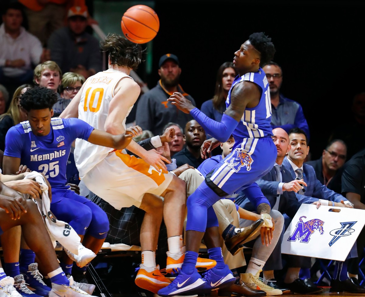 <strong>Tennessee forward John Fulkerson (left) falls into the Memphis bench after battling Tiger guard Damion Baugh (right) for a loose ball during action Saturday, Dec. 14, 2019 in Knoxville, Tennessee.</strong> (Mark Weber/Daily Memphian)