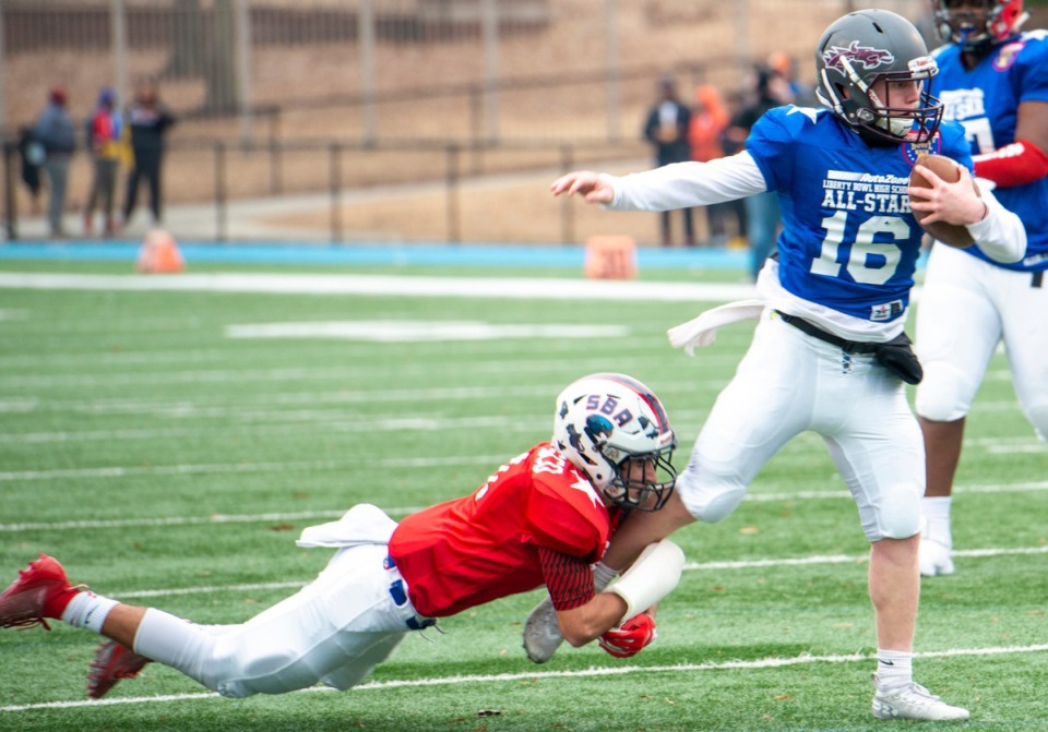 <strong>Red team defensive back Dante Carrasco from St. Benedict grabs the leg of Blue team quarterback Mitch Austin from Collierville at the Liberty Bowl High School All-Star&nbsp;&nbsp;game on Dec. 14, 2019, at MUS.</strong>&nbsp;(Greg Campbell/Special to The Daily Memphian)